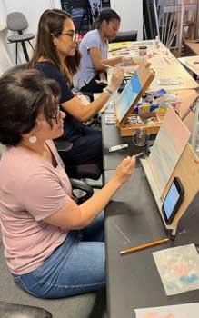 painting students work at their table easels