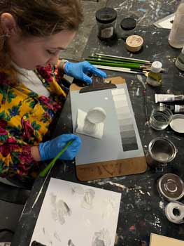 Painting student works on a series of oil painting exercises