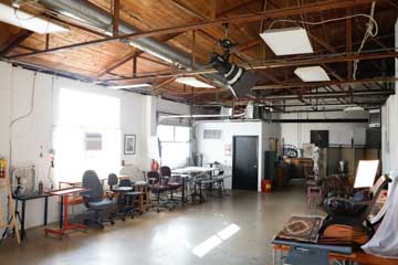 large open artist's studio studio with view of windows, loading dock door, and bathroom