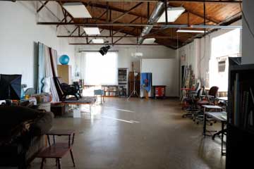 large open artist's studio with rafters and window light shining on floor